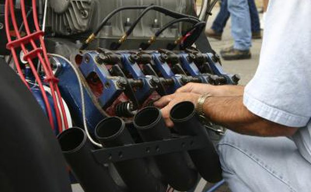 Механик, работающий на двигателе гоночной машины